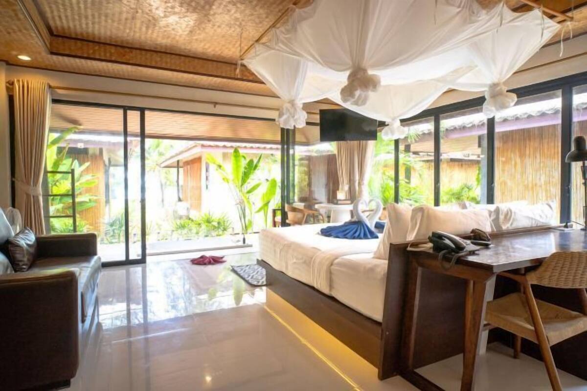 Une chambre moderne équipée d’un lit, d’un bureau et d’une grande fenêtre.