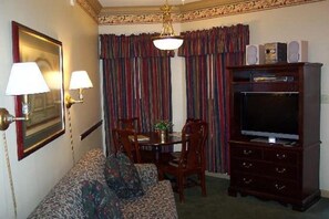 Relax in a traditional room with a large flat-screen TV, dining table, and comfortable sofa.