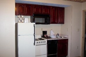 Functional kitchen with a refrigerator, microwave, stove, and sink.