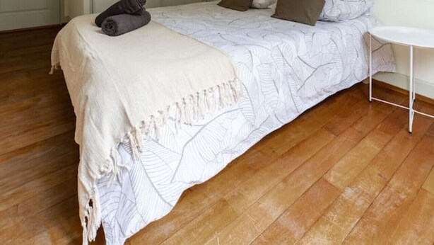 A bedroom with a bed, a bedside table, a chair, a wardrobe, and a door. - 2-bedroom designer apartment, Thermes district (Vichy)