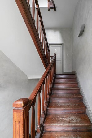 A wooden staircase with a handrail leading to a door at the top. - 2-bedroom designer apartment, Thermes district (Vichy)