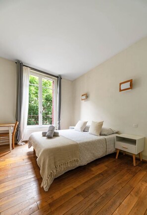Camera da letto con un letto, un comodino e vista sul verde.
