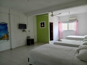 A room with two beds, a television, a small table, a wall with a painting, and a window with curtains. - Hotel Don Kike 55 (Mahahual)