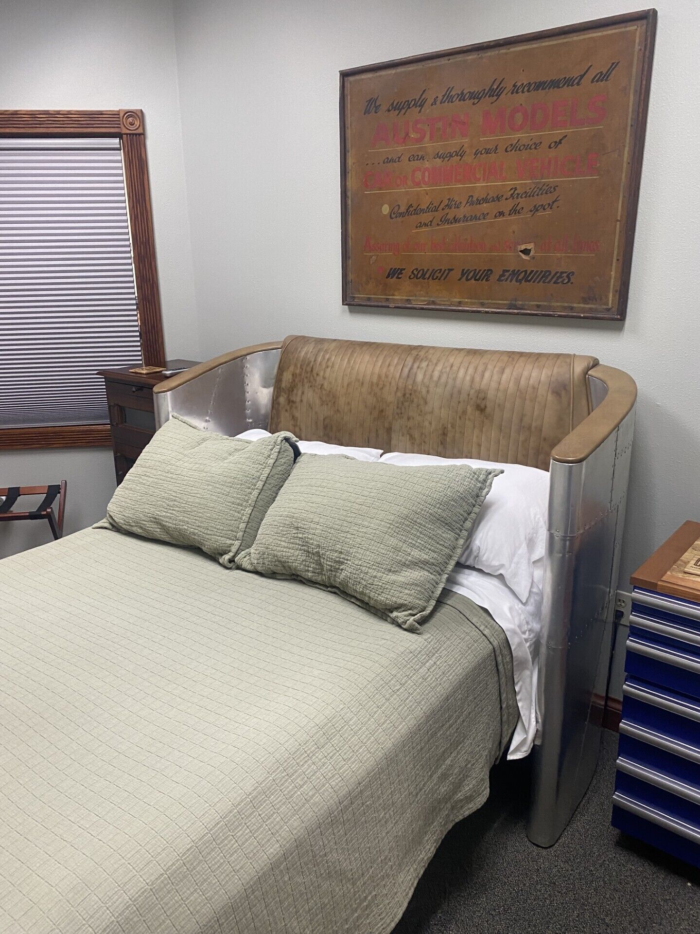A single bed with a metal frame, a wooden headboard, and two pillows.