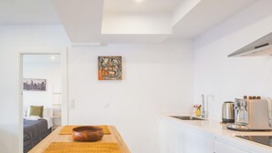 Eine kleine Küche mit einem Holztisch, einer Spüle und einer Kaffeemaschine.