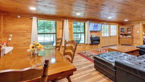 A wooden cabin interior with a dining table, chairs, a sofa, and a fireplace. - 6 Mi to Town: Robbinsville Apt w/ Deck & Grill (Robbinsville)