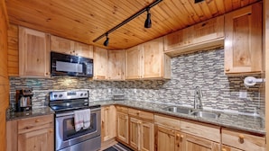 A kitchen with wooden cabinets, a stainless steel oven, a microwave, and a tiled backsplash. - 6 Mi to Town: Robbinsville Apt w/ Deck & Grill (Robbinsville)