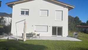 A two-story house with a patio, a swing set, and a barbecue grill. - Privatunterkunft in Wendisch Rietz, Deutschland (Wendisch Rietz)