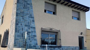 A two-story building with a stone facade and a flat roof.