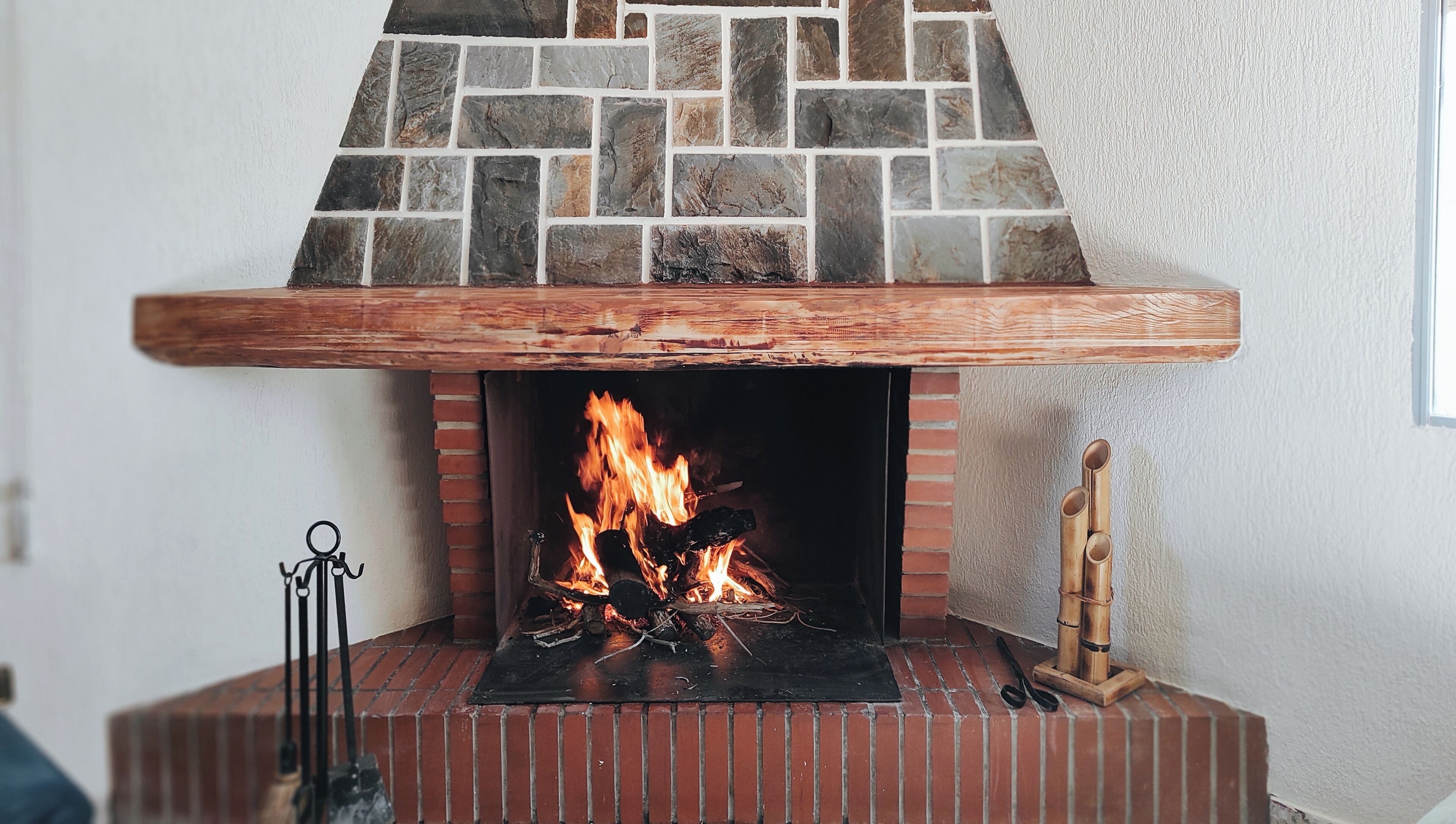 A fireplace with a stone facade and a wooden mantel.