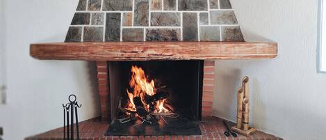 A fireplace with a stone facade and a wooden mantel.