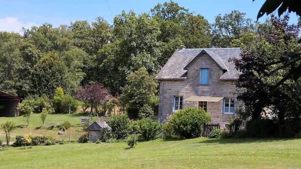 A stone house with a gabled roof, surrounded by lush greenery and trees. - La Cireygeade (St Martial de Gimel)