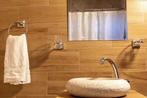 Bathroom features a round sink, metal towel ring, and a rectangular mirror.