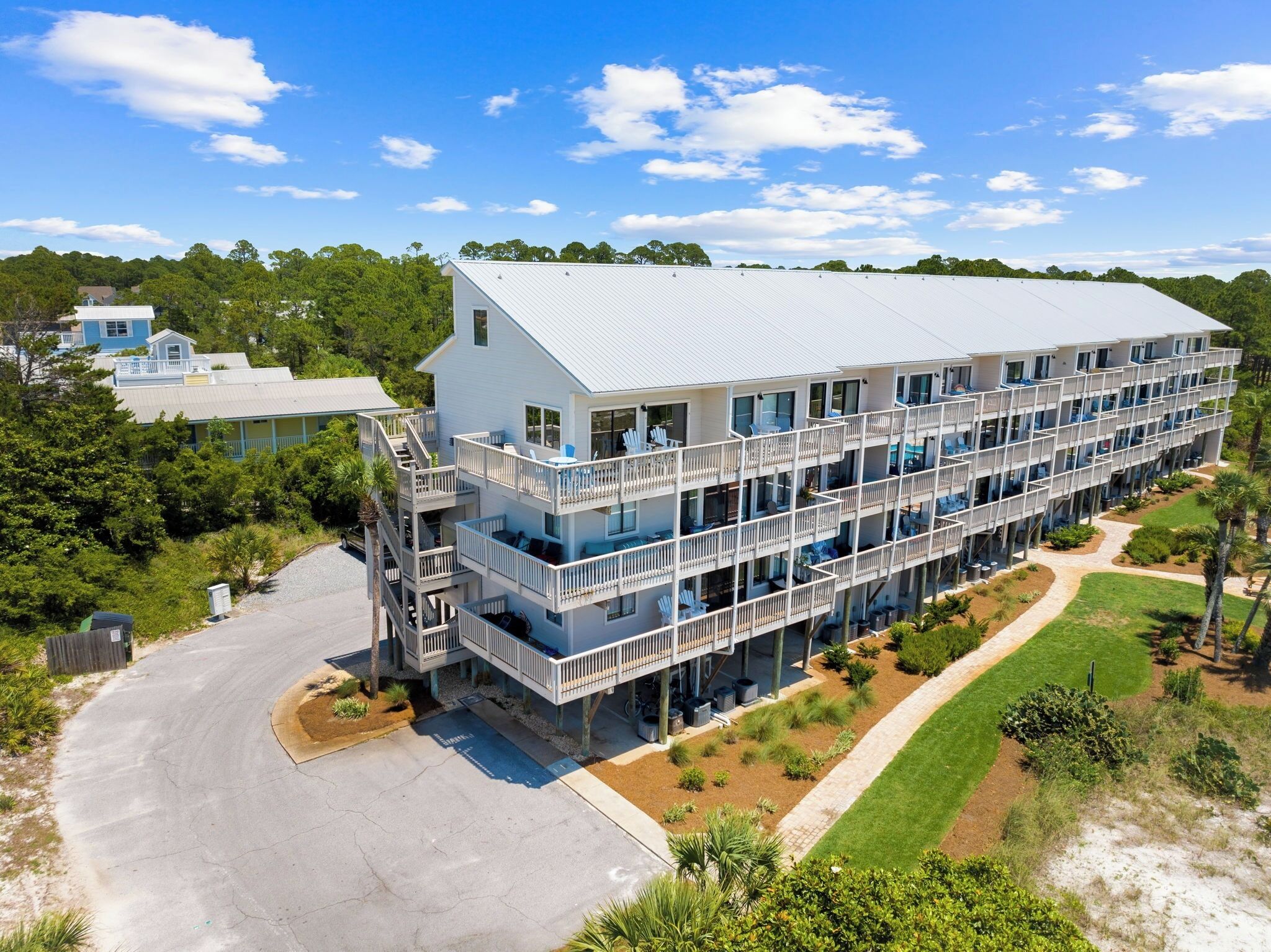 Et hotel med flere etager, altaner, parkeringsområde og anlagt have.