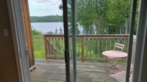 Una terraza de madera con vista a un lago y un bosque.