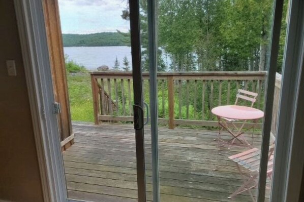 Una terraza de madera con vista a un lago y un bosque.