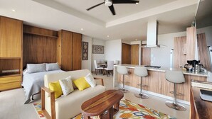 A modern apartment with a large bed, a sofa, a dining area, and a kitchen. - Beautiful new Studio in Puerto Vallarta with roof top pool and ocean view (Puerto Vallarta)