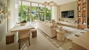 A modern living room with a dining area, large windows, and a TV mounted on the wall. - Pier Sixty-Six (Pier 66) (Fort Lauderdale)