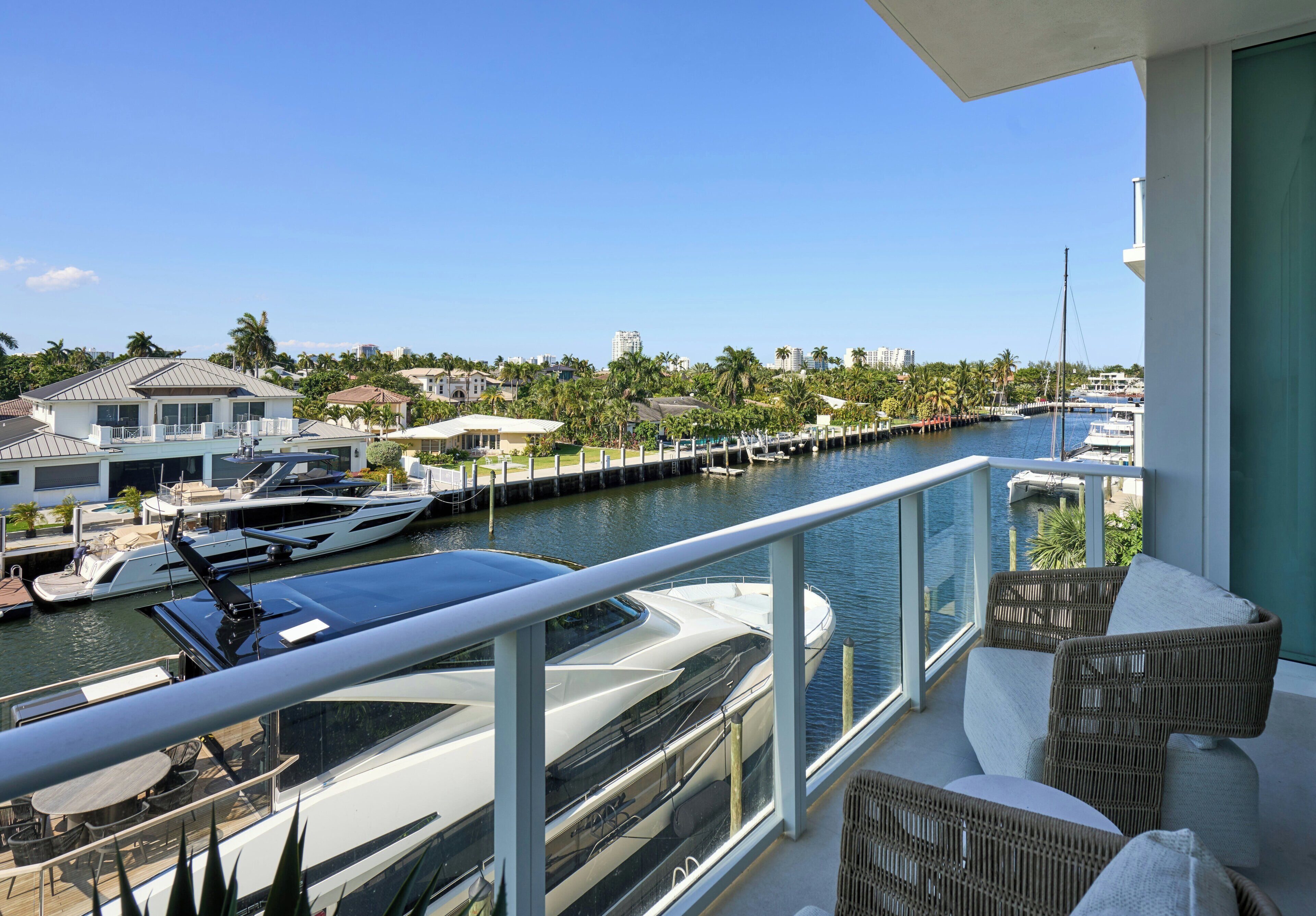Un balcon donnant sur un port de plaisance, des bateaux et un quartier résidentiel.
