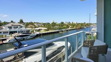 Un balcon donnant sur un port de plaisance, des bateaux et un quartier résidentiel.