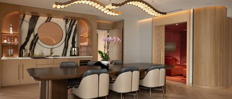 A modern dining area with a marble backsplash, a round table, and six chairs.