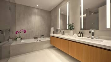 Une salle de bain moderne avec un grand miroir, une baignoire et un meuble-lavabo.