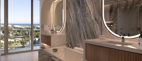 Un baño moderno con una bañera grande, paredes de mármol y vistas a la ciudad.