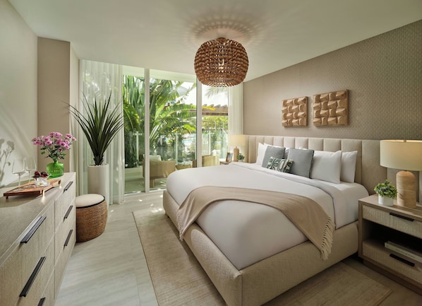 A modern bedroom with a large bed, a bedside table with a lamp, a decorative wall piece, and a view of the outdoors. - Pier Sixty-Six (Pier 66) (Fort Lauderdale)