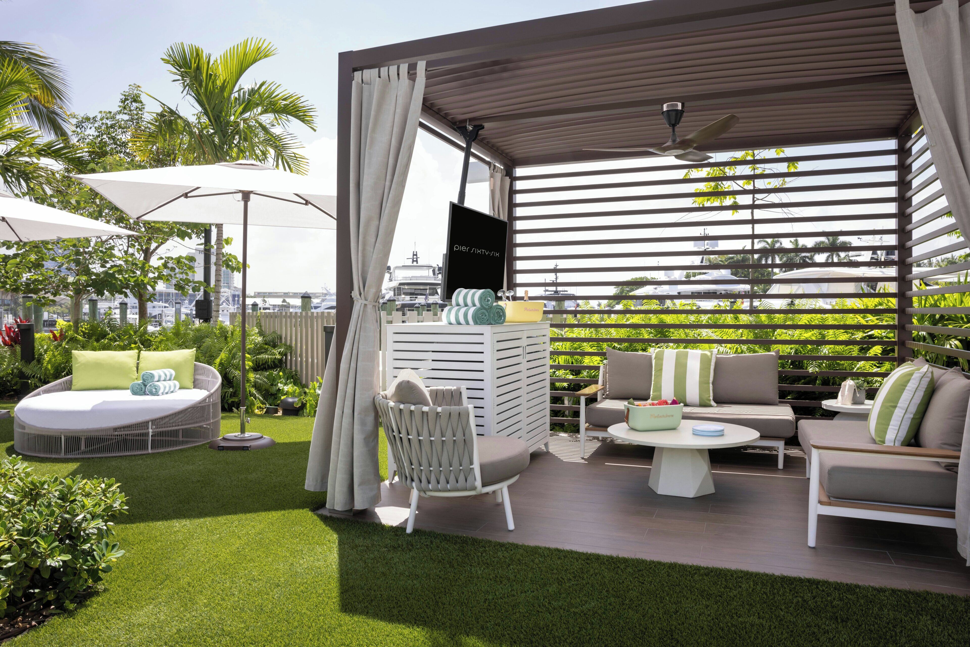 Un patio exterior con asientos, un televisor y vistas de la ciudad.