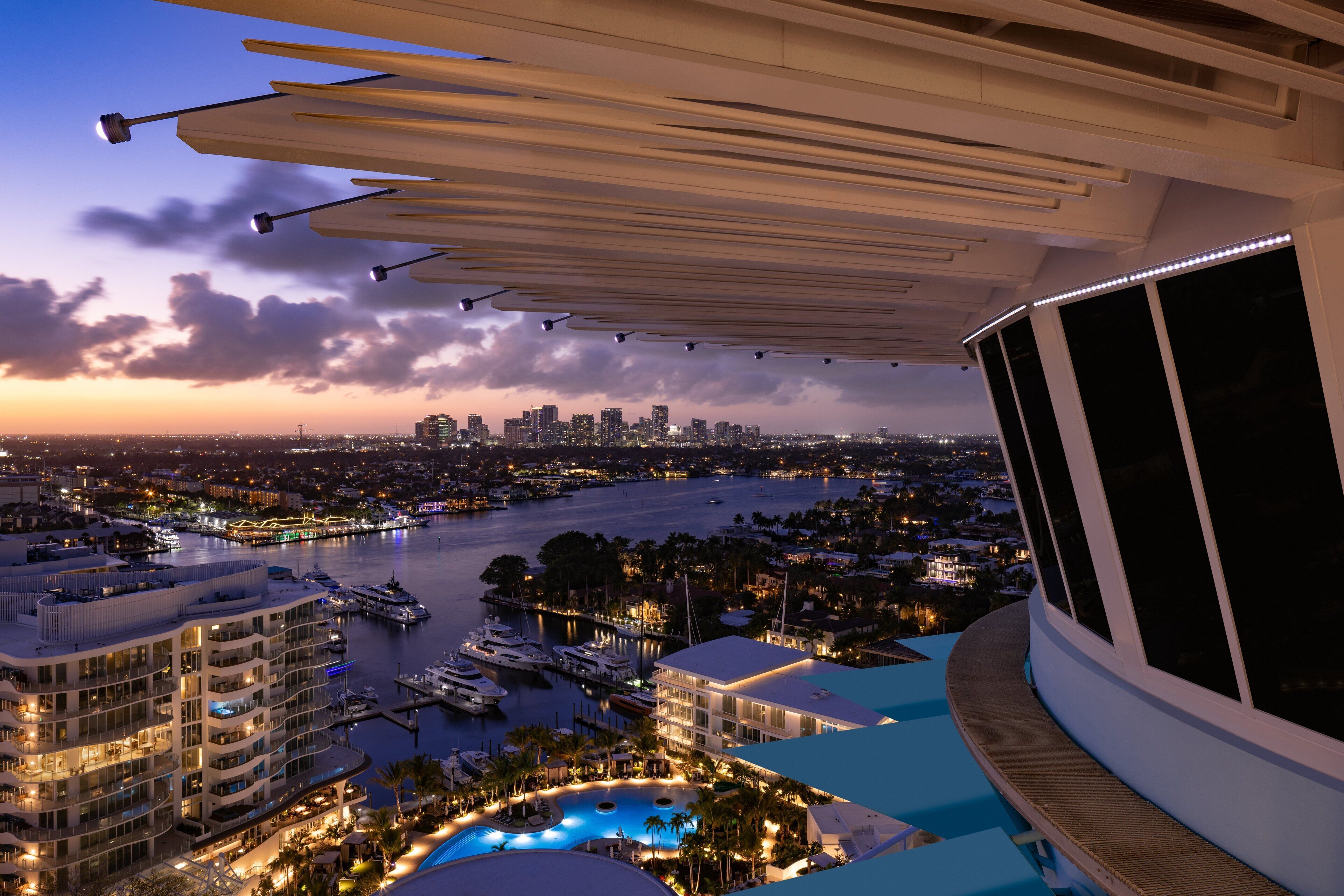 A high-rise hotel with a rooftop pool, marina, and city skyline views.