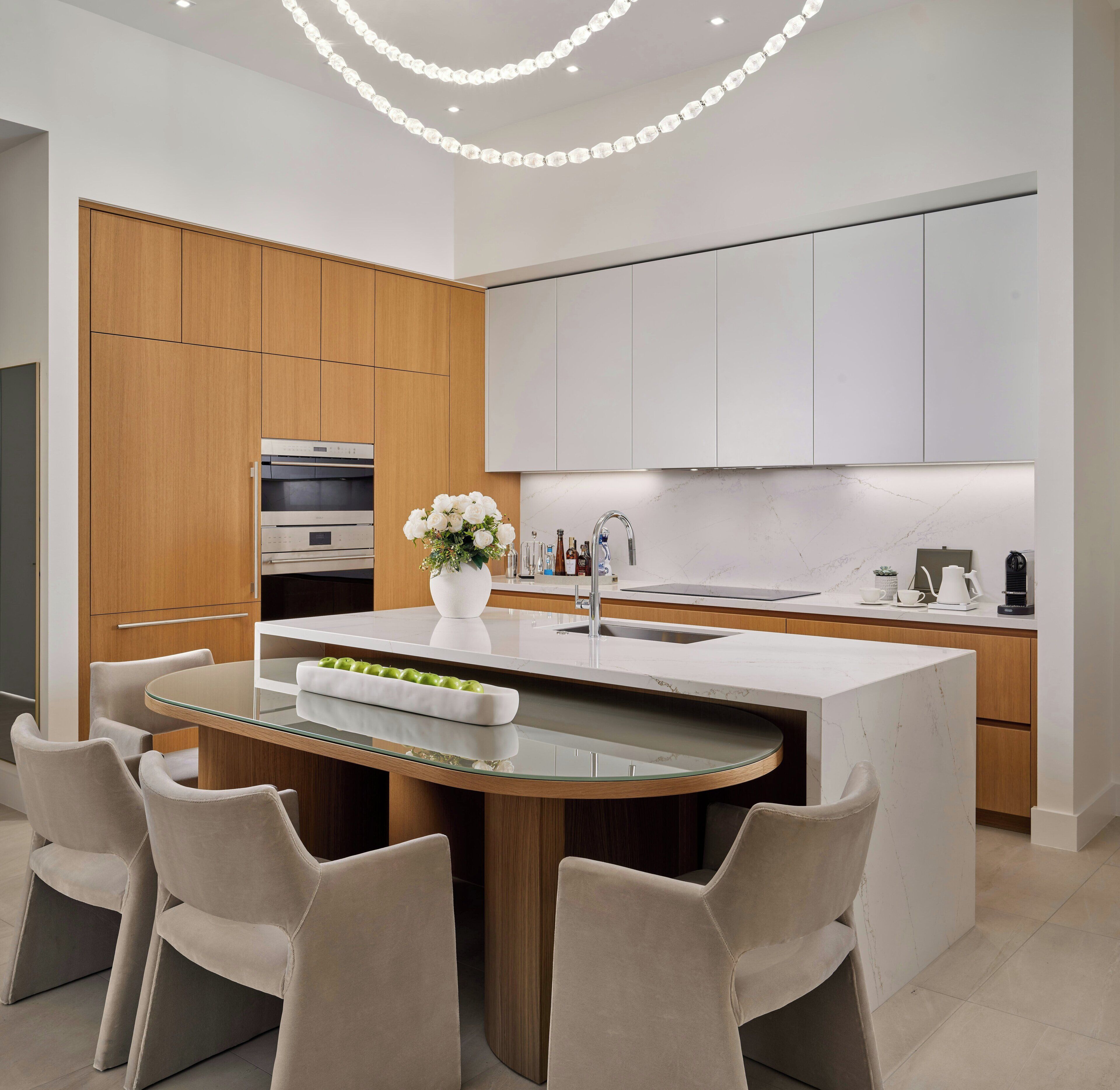 Una cocina moderna con una isla central, armarios de madera y un horno empotrado.