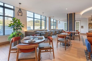 Enjoy communal dining in a spacious area with large windows and a variety of seating options.