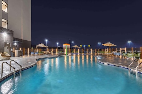 Una piscina al aire libre de temporada, sombrillas
