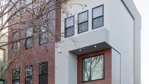 Un bâtiment moderne à deux étages, doté d’un toit plat, de grandes fenêtres et d’une clôture en bois.