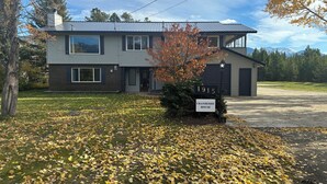 A two-story house with a number sign '1915' and a sign reading 'CRANBERRY HOUSE'. - Large newly renovated house.  Cozy and convenient.  (Valemount)
