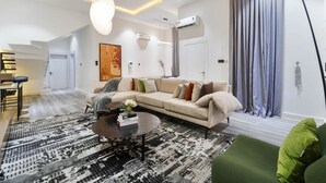 Una sala moderna con un sofá modular, una mesita de centro y una alfombra estampada.