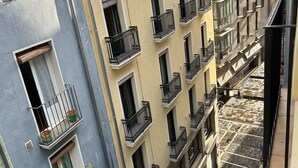 A multi-story building with balconies, a staircase, and a narrow street. - Casa Otano (Pamplona)