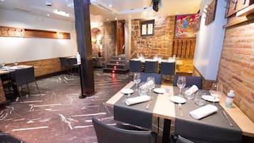 Un restaurante con suelo de mármol, paredes de piedra y mobiliario moderno.