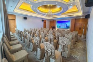 A conference room with rows of chairs, a projector screen, and a chandelier. - Vienna International Hotel (Dongguan Mayong Central Avenue) (Dongguan)
