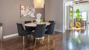 A dining area with a round table, black chairs, and a chandelier. - Duplex 3 Bed 2 Bath Apt Steps from Lincoln Square (Chicago)