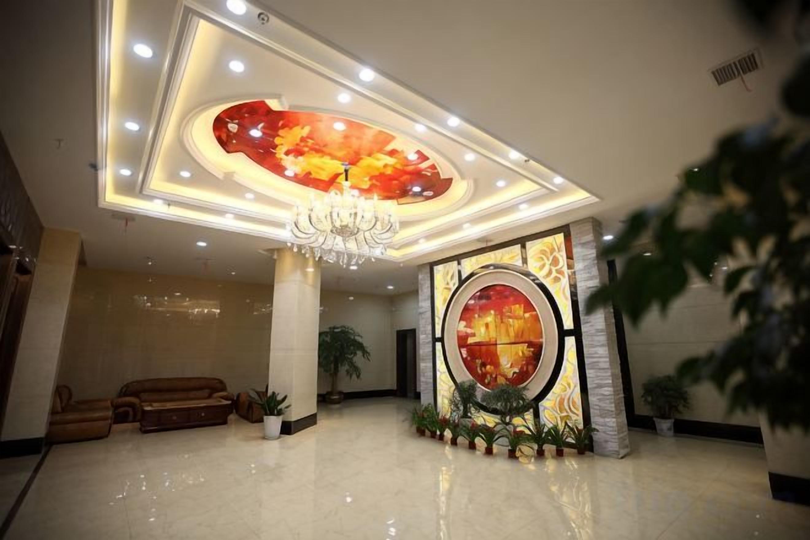 A lobby with a chandelier, a large circular artwork, and a reception desk.