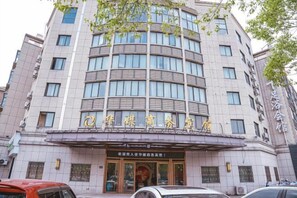 Ein mehrstöckiges Hotel mit markantem Eingang und Beschilderung.
