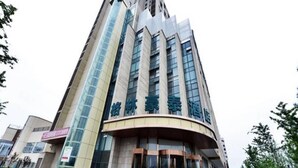 Ein modernes Hotel mit gebogenem Eingang, mehreren Etagen und einer markanten Glasfassade.