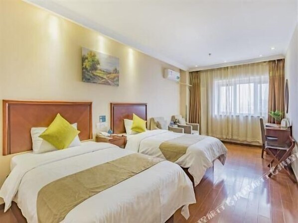 Habitació d'hotel amb dos llits, un escriptori i una cadira.