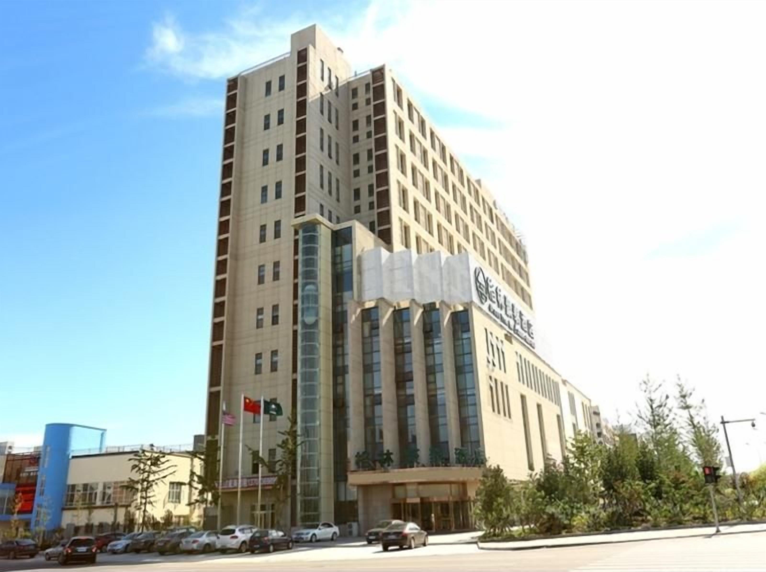 A tall hotel with multiple floors, large windows, and a prominent sign.