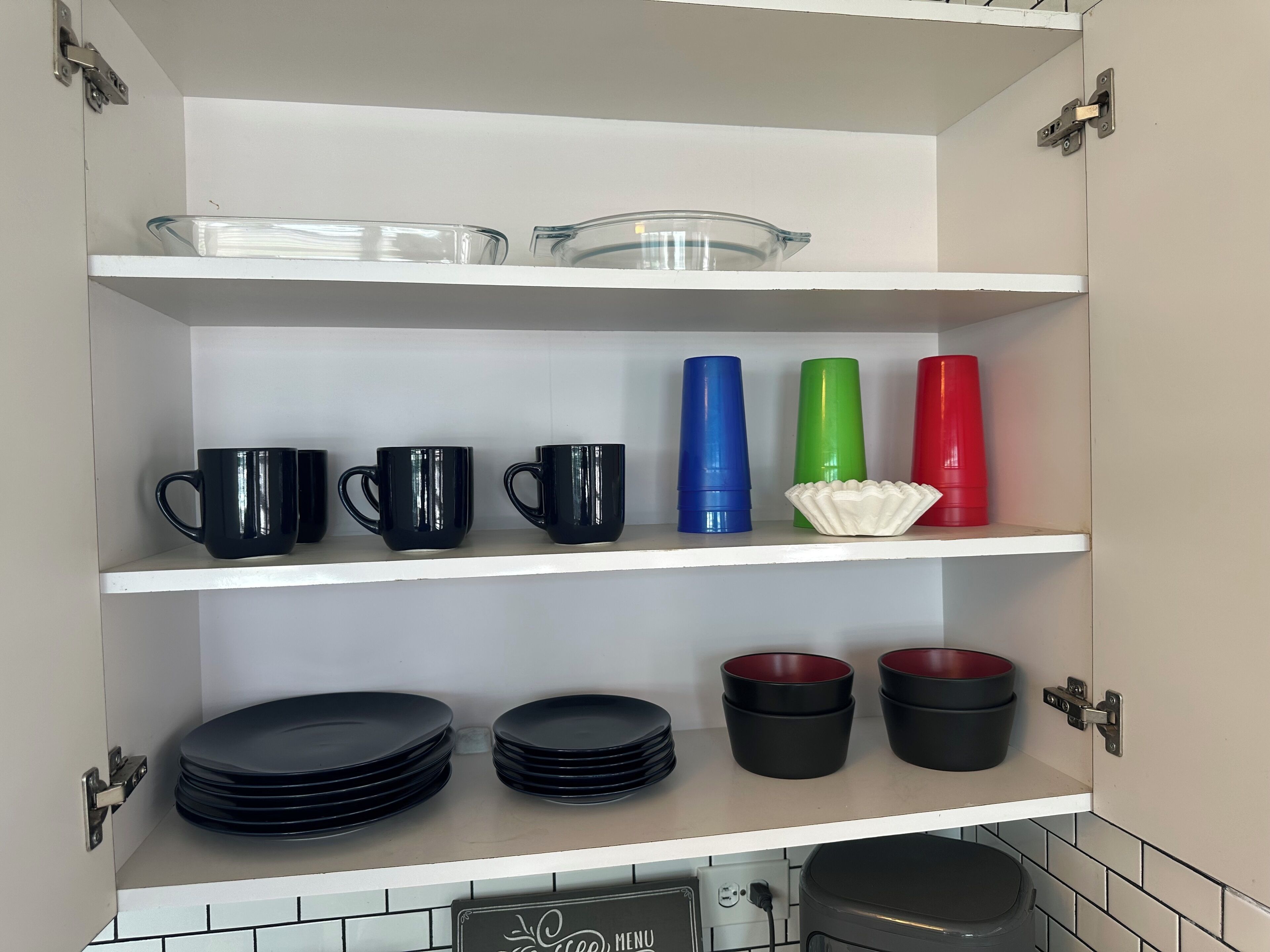 Un armario de cocina con repisas que contienen diversos utensilios de cocina.