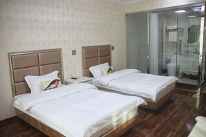 A hotel room with two beds, a bathroom with a glass shower, and a wooden floor. - Yandangshan Sunshine Hotel (Yueqing)