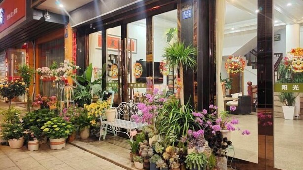 A storefront with a variety of potted plants and flowers displayed outside. - Yandangshan Sunshine Hotel (Yueqing)