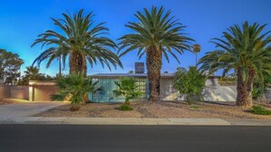 A residential property with a gated entrance, palm trees, and a clear blue sky. - Mid Century Modern near STRIP w Pool King Suite (Las Vegas)