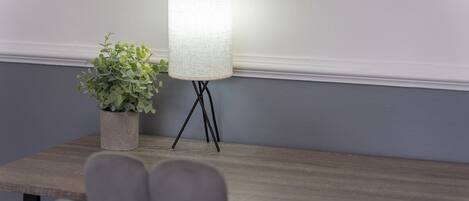 Una mesa con una lámpara y una planta en maceta.